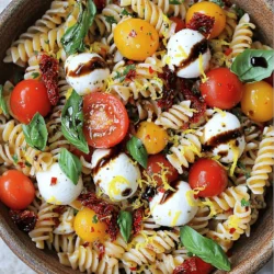 - 225 g Pasta (Fusilli oder Penne) - 240 ml frische Kirschtomaten, halbiert - 240 g Mozzarella-Kugeln, halbiert - 60 ml getrocknete Tomaten, gehackt - 125 ml frische Basilikumblätter, grob zerrissen - 45 ml Balsamico-Glasur - 30 ml extra natives Olivenöl - Salz und Pfeffer nach Geschmack - 1/4 Teelöffel rote Pfefferflocken (optional) Um einen leckeren Caprese Pasta Salad zu machen, brauchst du frische und einfache Zutaten. Die Hauptbestandteile wie Pasta, Kirschtomaten und Mozzarella sind wichtig. Sie sorgen für den klassischen Geschmack. Die zusätzlichen Zutaten bringen das Gericht auf die nächste Stufe. Die getrockneten Tomaten geben einen intensiven Geschmack. Frische Basilikumblätter sorgen für einen tollen Duft und Geschmack. Die Balsamico-Glasur macht alles noch besser. Die Gewürze sind das i-Tüpfelchen. Olivenöl bringt die Zutaten zusammen. Salz und Pfeffer sind wichtig für den Geschmack. Wenn du es etwas schärfer magst, füge die roten Pfefferflocken hinzu. Die Kombination dieser Zutaten macht deinen Salat frisch und lecker. Bereite alles vor und genieße den Prozess. Für das vollständige Rezept siehe die Full Recipe. Zuerst musst du Wasser vorbereiten. Nimm einen großen Topf und fülle ihn mit Wasser. Füge eine großzügige Prise Salz hinzu. Das Salz gibt der Pasta Geschmack. Bringe das Wasser zum Kochen. Koche die Pasta für etwa 8 bis 10 Minuten, bis sie al dente ist. Al dente bedeutet, dass die Pasta fest, aber nicht hart ist. Gieße die Pasta ab und spüle sie mit kaltem Wasser ab. Das stoppt den Kochprozess und kühlt die Nudeln ab. Jetzt ist es Zeit, die Hauptbestandteile zu mischen. Nimm eine große Schüssel und füge die gekochte Pasta hinzu. Gib die halbierten Kirschtomaten, Mozzarella-Kugeln und grob zerrissenen Basilikumblätter dazu. Füge auch die gehackten getrockneten Tomaten hinzu. Diese Mischung schmeckt frisch und bunt. Als nächstes bereitest du das Dressing vor. In einer kleinen Schüssel verrühre die Balsamico-Glasur, das Olivenöl, den Zitronenabrieb, Salz, Pfeffer und die roten Pfefferflocken (wenn du Schärfe magst). Rühre alles gut um, bis die Sauce gleichmäßig ist. Gieße das Dressing über den Salat. Vermenge alles vorsichtig, damit die Zutaten gleichmäßig bedeckt sind. Es ist wichtig, dass jede Nudel und jedes Gemüse gut mit der Sauce in Kontakt kommt. Lasse den Nudelsalat mindestens 30 Minuten im Kühlschrank ziehen. So können sich die Aromen gut entfalten. Wenn du den Salat kalt servierst, schmeckt er am besten. Du kannst ihn auch mit frischem Basilikum garnieren, um das Aussehen zu verbessern. Für das komplette Rezept, schau dir [Full Recipe] an. Wie erreicht man die richtige Konsistenz beim Kochen? Koche die Pasta in einem großen Topf mit viel Wasser. Füge eine großzügige Prise Salz hinzu. Achte darauf, die Pasta nur bis al dente zu kochen, also etwas bissfest. So bleibt sie beim Mischen mit den anderen Zutaten perfekt. Um die Pasta abzukühlen, gieße sie nach dem Kochen in ein Sieb. Spüle die Nudeln unter kaltem Wasser ab. Dies stoppt den Garprozess und hilft, die Pasta nicht zusammenkleben zu lassen. Probiere verschiedene Dressing-Variationen, um neue Geschmäcker zu entdecken. Ein einfaches Balsamico-Dressing ist klassisch, aber du kannst auch Olivenöl mit Zitronensaft mischen. Das bringt Frische und einen schönen Kick. Verwende frische Kräuter, um mehr Aromen hinzuzufügen. Basilikum ist ein Muss für Caprese Pasta Salad. Du kannst auch Petersilie oder Oregano ausprobieren. Frische Kräuter geben dem Gericht mehr Tiefe und Geschmack. Die Garnierung macht viel aus. Füge frische Basilikumblätter obenauf hinzu. Das sieht toll aus und bringt zusätzlichen Geschmack. Du kannst auch etwas geriebenen Parmesan darüber streuen. Serviere den Salat in einer großen Schüssel oder auf einem schönen Teller. So sieht er einladend aus. Stelle sicher, dass er gut gekühlt ist, bevor du ihn servierst. So genießen alle die frischen Aromen am besten. {{image_4}} Du kannst dem Caprese Pasta Salad etwas Abwechslung geben. Eine Avocado bringt Cremigkeit und einen milden Geschmack. Einfach die Avocado in Würfel schneiden und vorsichtig unter die anderen Zutaten mischen. Oliven sind eine weitere tolle Option. Sie fügen einen salzigen Geschmack hinzu, der gut zu den Tomaten passt. Verwende schwarze oder grüne Oliven, je nach deinem Geschmack. Wenn du eine vegane Variante möchtest, ersetze den Mozzarella durch pflanzlichen Mozzarella. Er ist oft auf Basis von Nüssen oder Soja. Für das Dressing kannst du Balsamico-Essig anstelle der Balsamico-Glasur verwenden. Es gibt auch viele leckere Alternativen, wie Apfelessig oder Zitronensaft. Diese sorgen für den nötigen Säurekick. Die Zutaten können je nach Saison variieren. Im Sommer sind reife Tomaten und frisches Basilikum ideal. Im Herbst kannst du Kürbis oder geröstete Paprika hinzufügen. Diese bringen neue Aromen in den Salat. Experimentiere mit saisonalen Gemüsen für einen besonderen Twist. Um deinen Caprese Pasta Salad frisch zu halten, lagere ihn in einem luftdichten Behälter. Stelle sicher, dass die Temperatur im Kühlschrank bei etwa 4 Grad Celsius liegt. So bleiben die Aromen intensiv. Der Salat hält sich bis zu drei Tage. Nach dieser Zeit kann die Qualität nachlassen. Du kannst die Zutaten im Voraus vorbereiten. Koche die Pasta und schneide das Gemüse einen Tag vorher. So sparst du Zeit am Tag des Servierens. Allerdings solltest du die Sauce erst kurz vor dem Servieren hinzufügen, damit der Salat frisch bleibt. Einfrieren von Zutaten ist nicht ideal. Die Textur der frischen Zutaten leidet. Wenn du Reste hast, benutze sie in anderen Gerichten, anstatt sie einzufrieren. Hast du Reste vom Caprese Pasta Salad? Das ist super! Du kannst ihn als Füllung für ein Sandwich oder Wrap verwenden. Eine weitere Idee ist, ihn in Omeletts zu mischen. Wenn du noch frische Zutaten hast, versuche sie in einer Suppe oder einem anderen Salat zu verwenden. Das gibt dir neue, leckere Möglichkeiten, den Geschmack zu genießen. Der Caprese Pasta Salad bleibt im Kühlschrank etwa drei bis fünf Tage frisch. Achte darauf, ihn in einem luftdichten Behälter zu lagern. So bleibt er knackig und lecker. Nach ein paar Tagen kann die Pasta jedoch etwas weicher werden. Daher genieße ihn am besten frisch! Ja, du kannst andere Käsesorten verwenden! Feta oder Ziegenkäse sind tolle Alternativen zu Mozzarella. Diese Käsesorten bringen unterschiedliche Geschmäcker und Texturen. Wenn du etwas Cremiges möchtest, versuche Ricotta. Experimentiere mit deinen Lieblingskäsen, um neue Aromen zu entdecken. Zu Caprese Pasta Salad passen viele Beilagen gut. Hier sind einige Vorschläge: - Gegrilltes Gemüse wie Zucchini oder Paprika. - Bruschetta mit frischen Tomaten und Basilikum. - Ein einfacher grüner Salat mit einem leichten Dressing. Diese Beilagen ergänzen den Salat perfekt und sorgen für ein ausgewogenes Essen. Zusammenfassend bietet das Rezept für Caprese Pasta Salad eine einfache, köstliche Kombination aus frischen Zutaten. Sie brauchen nur Pasta, Kirschtomaten und Mozzarella. Der Balsamico und die Gewürze verleihen dem Gericht Tiefe. Experimentieren Sie mit Variationen wie Avocado oder veganem Käse. Beachten Sie, wie Sie Ihren Salat lagern und vorbereiten können. Mit frischen Kräutern und kreativen Garnierungen wird jeder Biss zum Genuss. Genießen Sie diesen Salat, wann immer Sie frische Aromen lieben!